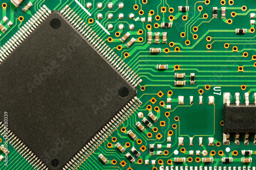 Close-up of electronic circuit board PCB with microchip, processor, integrated circuits, resistances and electronic connections. Top view. photo