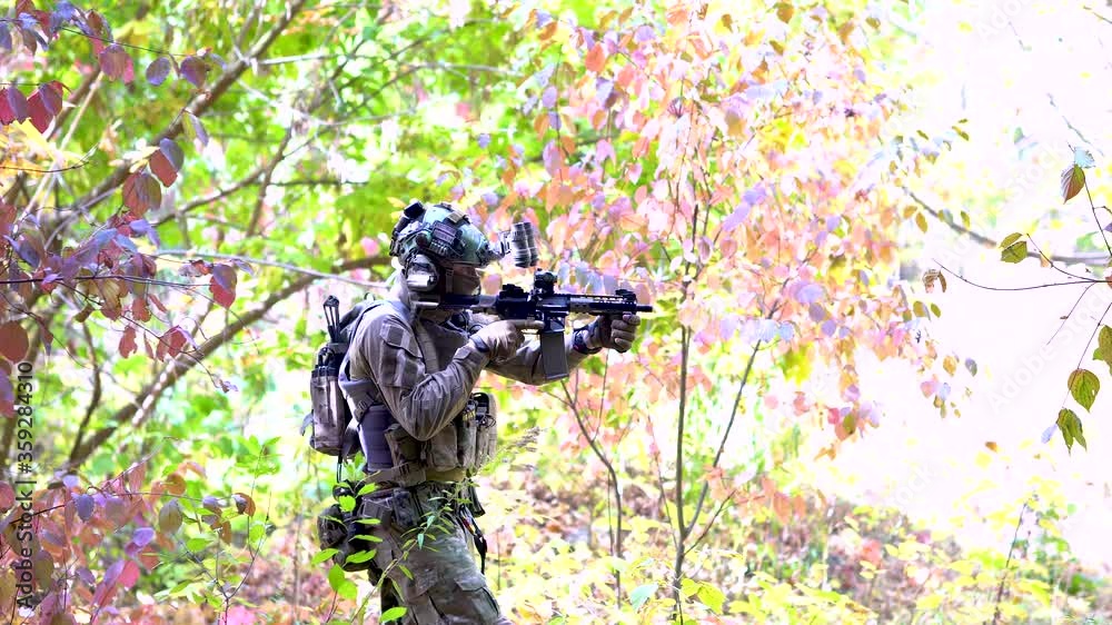Airsoft man with machine gun. Soldier slink along the wall of broken building. View from broken building Airsoft man with machine gun. Soldier slink along the wall of broken building. View from broken building