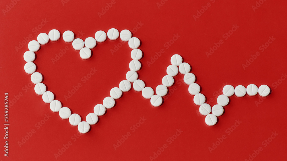 Top view of heart and cardiogram made of white pills over red background. Heart and cardiovascular disease, health and treatment concept Top view of heart and cardiogram made of white pills over red background. Heart and cardiovascular disease, health and treatment concept