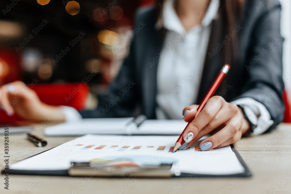 Business woman checks charts and refreshes financial progress. The girl analyzes the business model in the workplace. Business woman checks charts and refreshes financial progress. The girl analyzes the business model in the workplace.