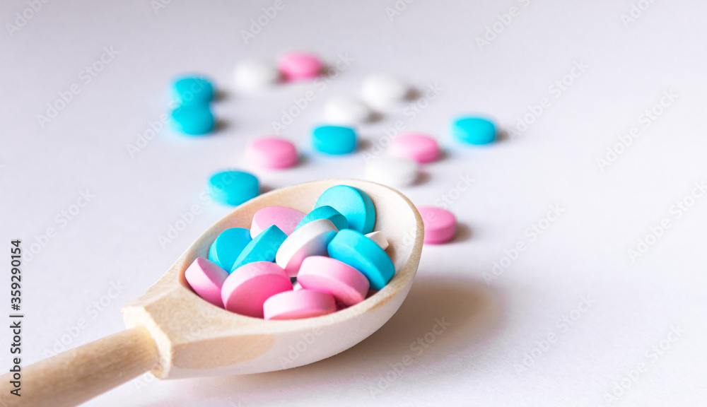 Assorted pharmaceutical medicine pills on wooden spoon Assorted pharmaceutical medicine pills on wooden spoon