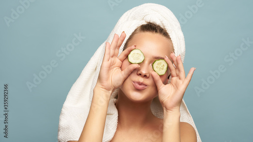 Beautiful young woman holding slices of cucumber. Skin care and treatment, spa, natural beauty and cosmetology