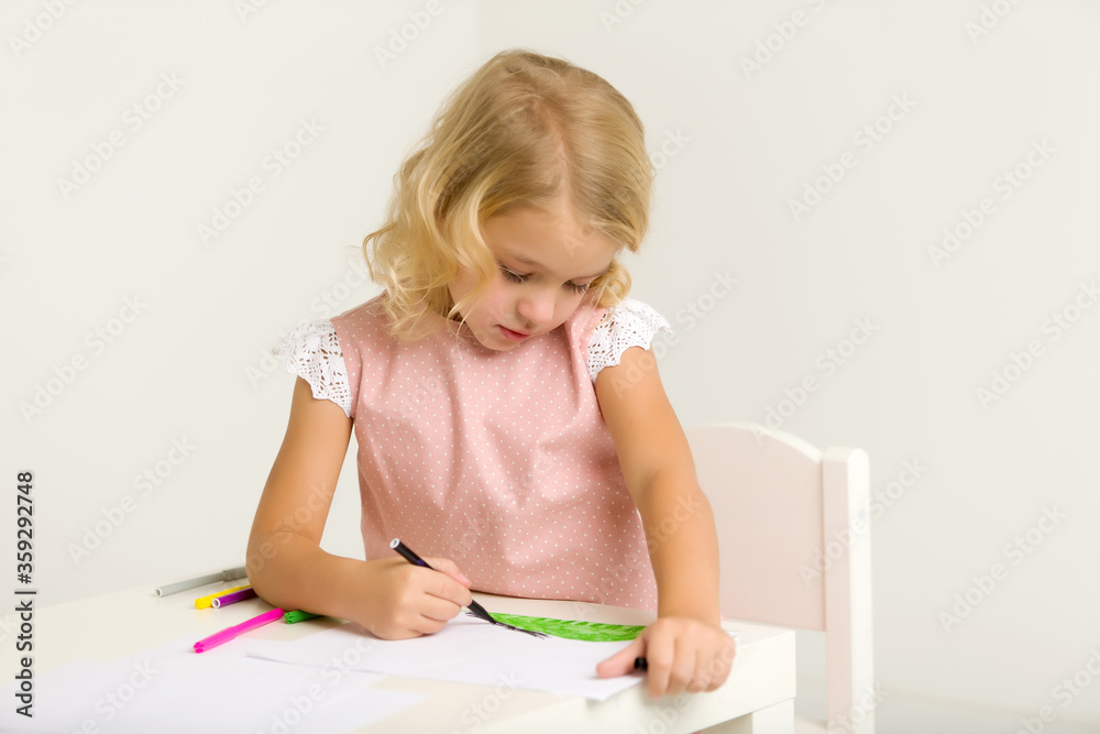 A little girl is drawing at the table. A little girl is drawing at the table.