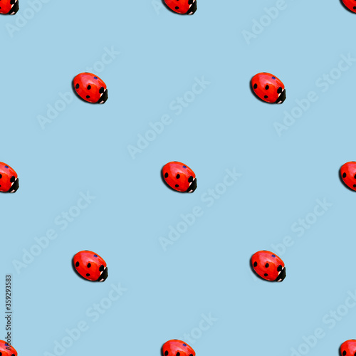 ladybug or ladybird seamless pattern isolated over blue background. minimal summer concept.