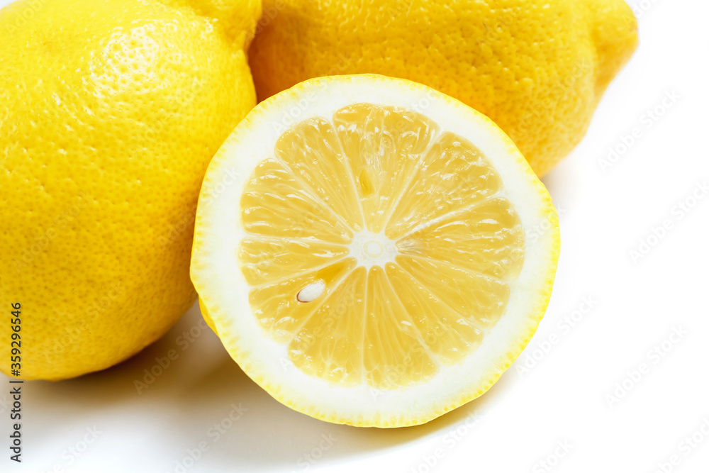 Two whole lemons and one half lemon isolated on a white background. Two whole lemons and one half lemon isolated on a white background.