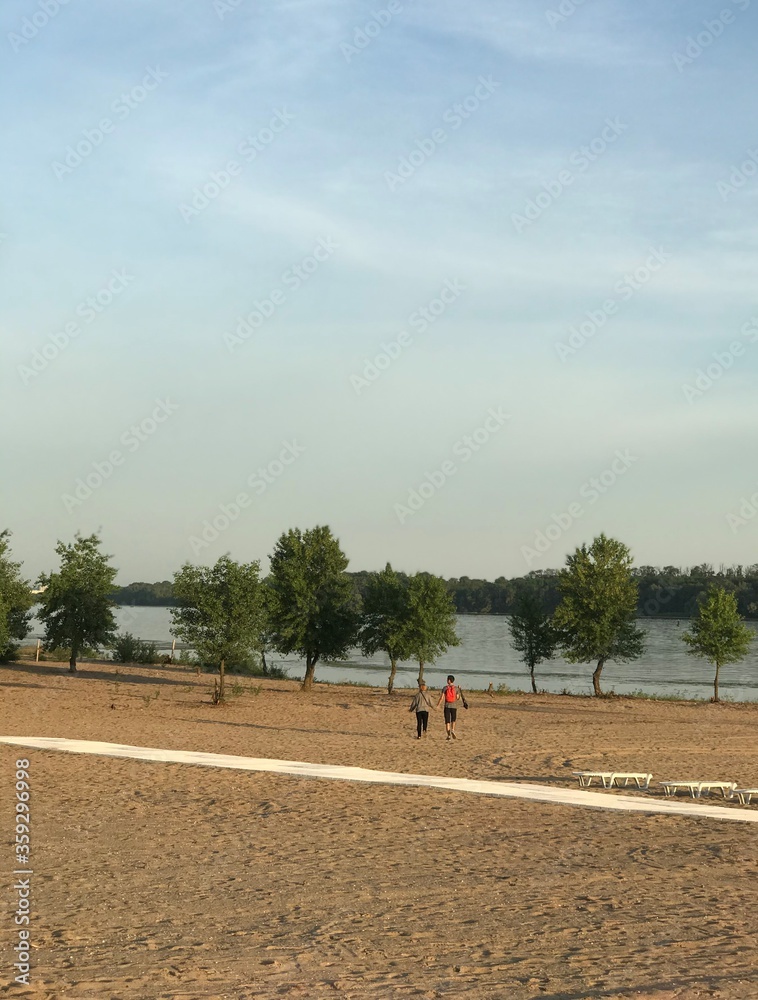 Obraz premium landscape beach near the river along the path in the distance pass people