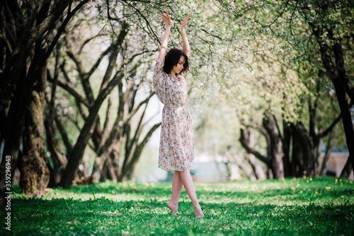 Woman ballerina in blooming garden. pink. ballet. portrait of dancing girl outdoor. fashion and style