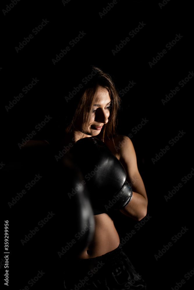 Female boxer training in the dark ring. Silhouette. Boxing concept. Fighter woman fist close up. Sexy girl with perfect body in boxing gloves at gym. concept of health and sport. Female boxer training in the dark ring. Silhouette. Boxing concept. Fighter woman fist close up. Sexy girl with perfect body in boxing gloves at gym. concept of health and sport.