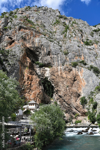 Blagaj / Bosnia and Herzegovina - 06 June 2020: Dervish tekke bellow huge cliff. Religion touristic place in Herzegovina.  photo