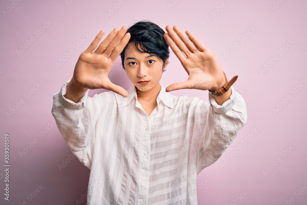 Young beautiful asian girl wearing casual shirt standing over isolated pink background doing frame using hands palms and fingers, camera perspective Young beautiful asian girl wearing casual shirt standing over isolated pink background doing frame using hands palms and fingers, camera perspective