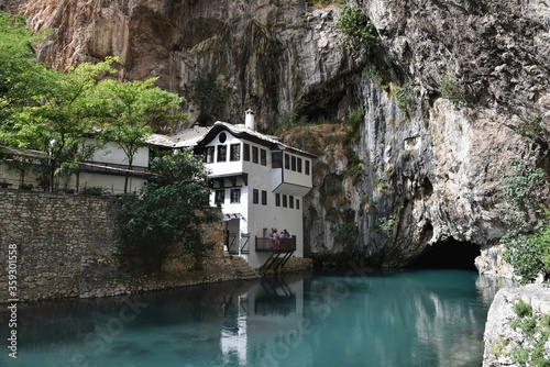 Blagaj / Bosnia and Herzegovina - 06 June 2020: Dervish tekke bellow huge cliff. Religion touristic place in Herzegovina.  photo