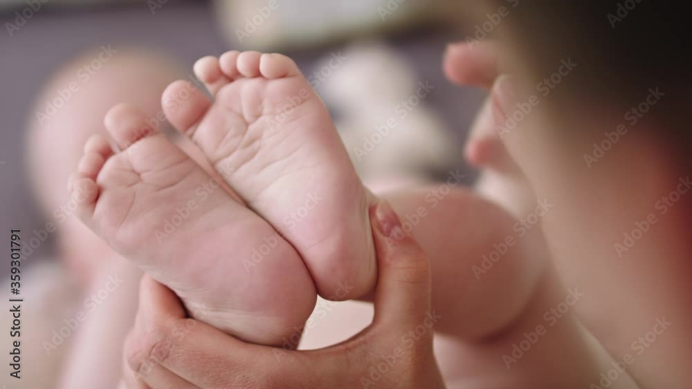 Mother massaging and tickling small baby feet. close up slow motion shot. Mother massaging and tickling small baby feet. close up slow motion shot.