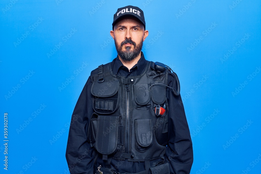 Young handsome man wearing police uniform with serious expression on face. simple and natural looking at the camera. Young handsome man wearing police uniform with serious expression on face. simple and natural looking at the camera.
