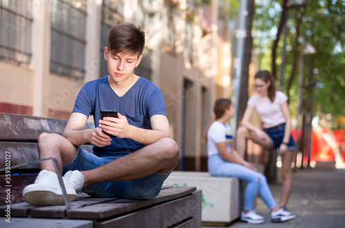 Teenage boy absorbed in online chat on mobile phone