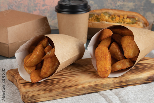 Eco packaging - potato wedges in craft packaging for delivery service. Vegan food. photo