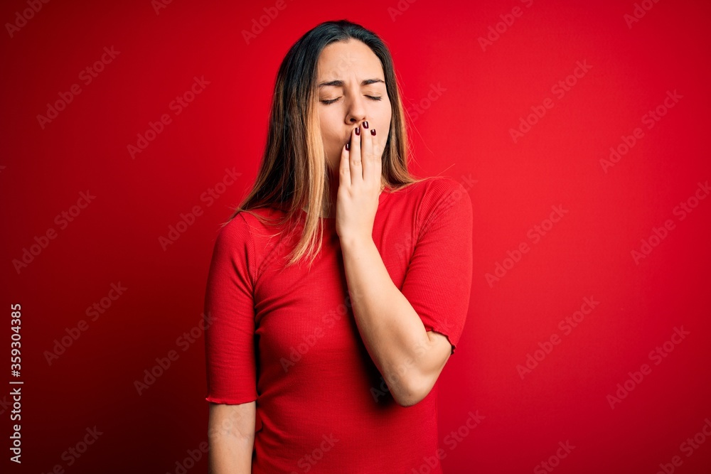 Young beautiful blonde woman with blue eyes wearing casual t-shirt over red background bored yawning tired covering mouth with hand. Restless and sleepiness. Young beautiful blonde woman with blue eyes wearing casual t-shirt over red background bored yawning tired covering mouth with hand. Restless and sleepiness.