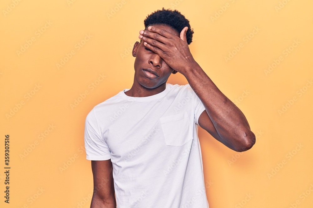Young african american man wearing casual clothes covering eyes with hand, looking serious and sad. sightless, hiding and rejection concept Young african american man wearing casual clothes covering eyes with hand, looking serious and sad. sightless, hiding and rejection concept