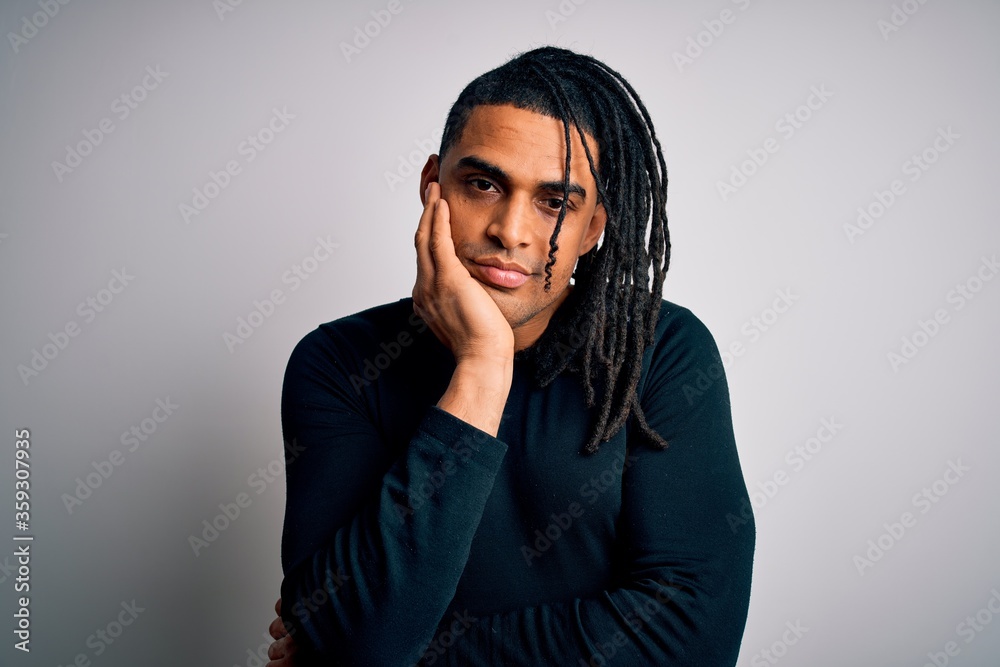 Young handsome african american man with dreadlocks wearing black casual sweater thinking looking tired and bored with depression problems with crossed arms. Young handsome african american man with dreadlocks wearing black casual sweater thinking looking tired and bored with depression problems with crossed arms.