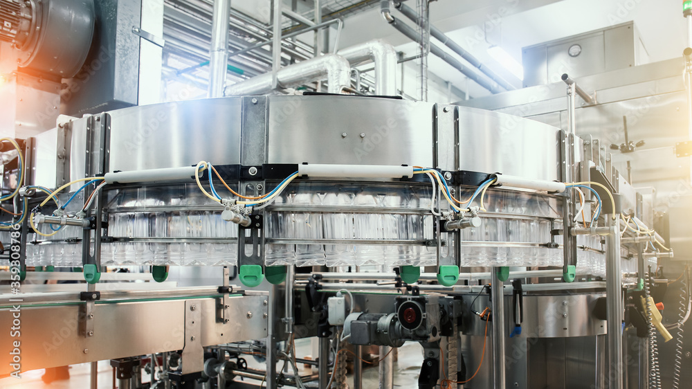 Industrial machine conveyor with plastic bottles in beverage factory, industry equipment. Industrial machine conveyor with plastic bottles in beverage factory, industry equipment.
