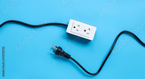 Electrical power strip and plug on blue background.