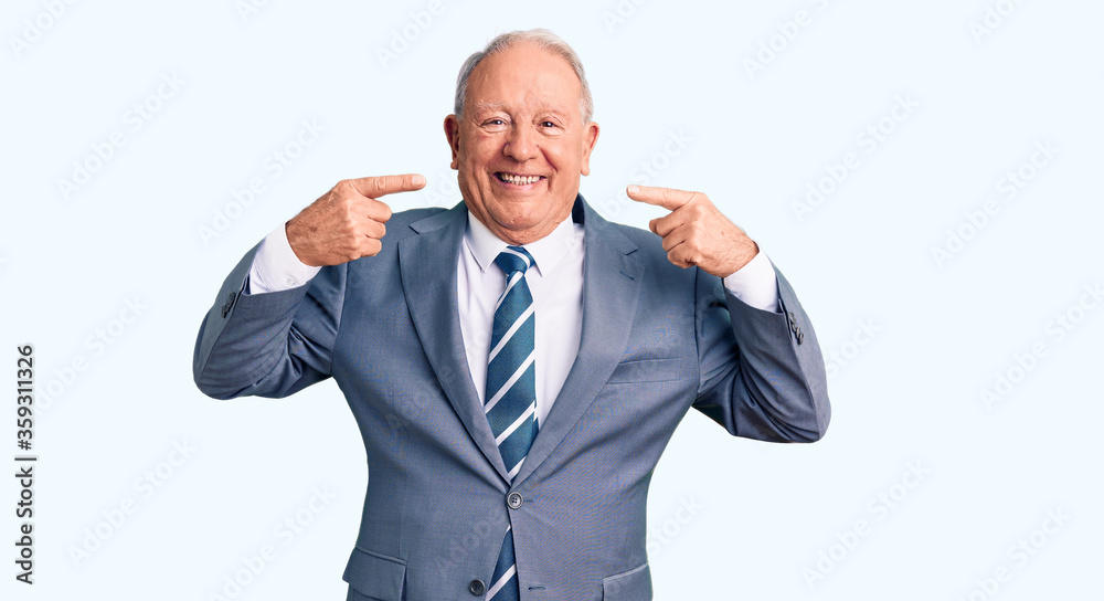 Senior handsome grey-haired man wearing elegant suit smiling cheerful showing and pointing with fingers teeth and mouth. dental health concept. Senior handsome grey-haired man wearing elegant suit smiling cheerful showing and pointing with fingers teeth and mouth. dental health concept.