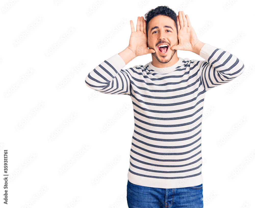 Young hispanic man wearing casual clothes smiling cheerful playing peek a boo with hands showing face. surprised and exited Young hispanic man wearing casual clothes smiling cheerful playing peek a boo with hands showing face. surprised and exited