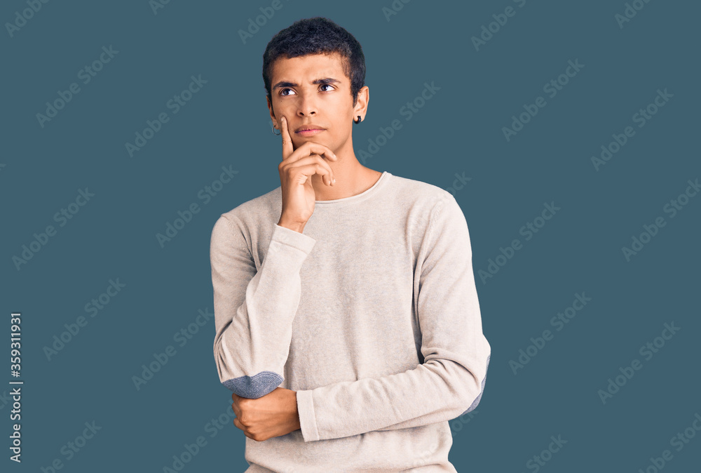 Young african amercian man wearing casual clothes with hand on chin thinking about question, pensive expression. smiling with thoughtful face. doubt concept.