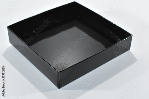 Czarne tekturowe pudełko na białym tle.