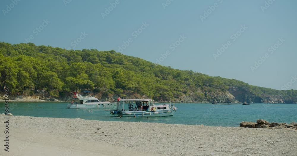 Yacht and boat in a picturesque bay. People swim near the yacht. Yacht and boat in a picturesque bay. People swim near the yacht.