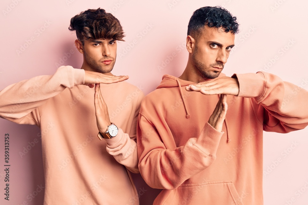 Young gay couple wearing casual clothes doing time out gesture with hands, frustrated and serious face Young gay couple wearing casual clothes doing time out gesture with hands, frustrated and serious face