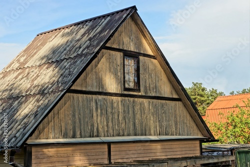 gray brown wooden attic of a rural private house with one window 