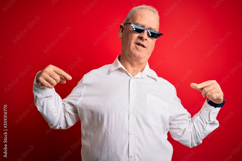 Middle age hoary man wearing funny sunglasses over isolated red background looking confident with smile on face, pointing oneself with fingers proud and happy. Middle age hoary man wearing funny sunglasses over isolated red background looking confident with smile on face, pointing oneself with fingers proud and happy.