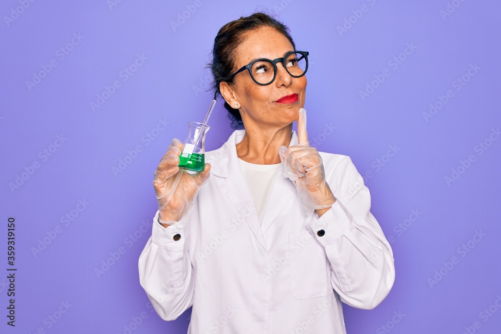 Middle age senior scientist woman wearing laboratory coat holding research test tube serious face thinking about question, very confused idea Middle age senior scientist woman wearing laboratory coat holding research test tube serious face thinking about question, very confused idea