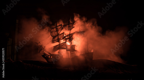 Fotografie Black silhouette of the pirate ship in night
