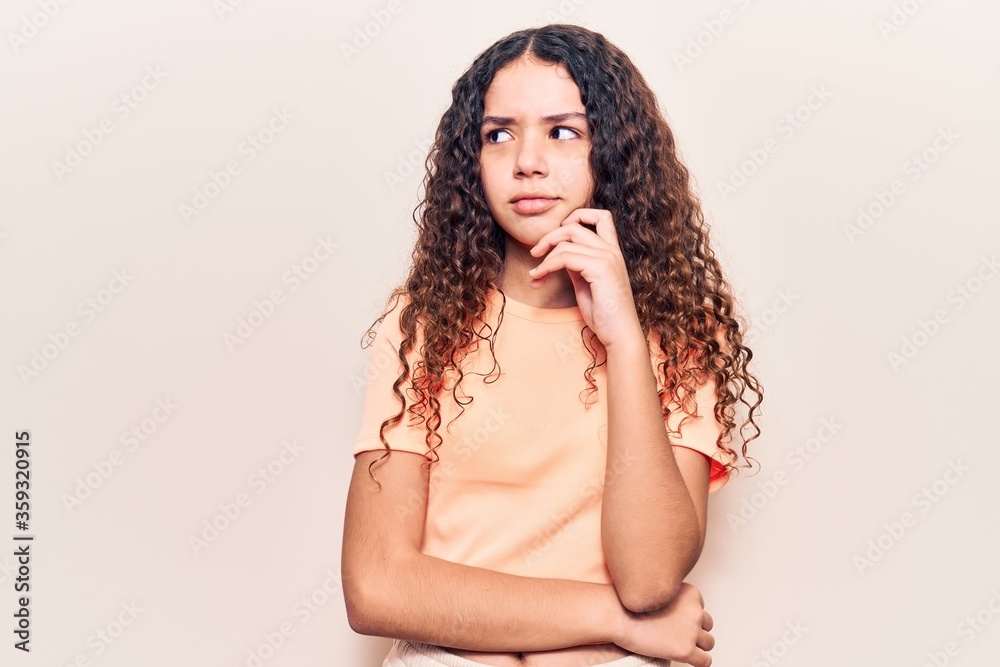 Beautiful kid girl with curly hair wearing casual clothes serious face thinking about question with hand on chin, thoughtful about confusing idea Beautiful kid girl with curly hair wearing casual clothes serious face thinking about question with hand on chin, thoughtful about confusing idea
