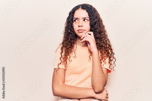Beautiful kid girl with curly hair wearing casual clothes serious face thinking about question with hand on chin  thoughtful about confusing idea