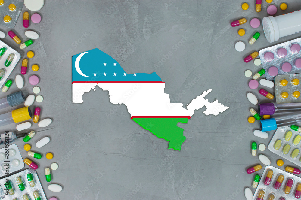 Obraz premium The Uzbekistan State began research for treatment and medicine to combat the pandemic outbreak disease coronavirus. Medicine, pills, needles, syringes and Uzbekistan map and flag on gray background.