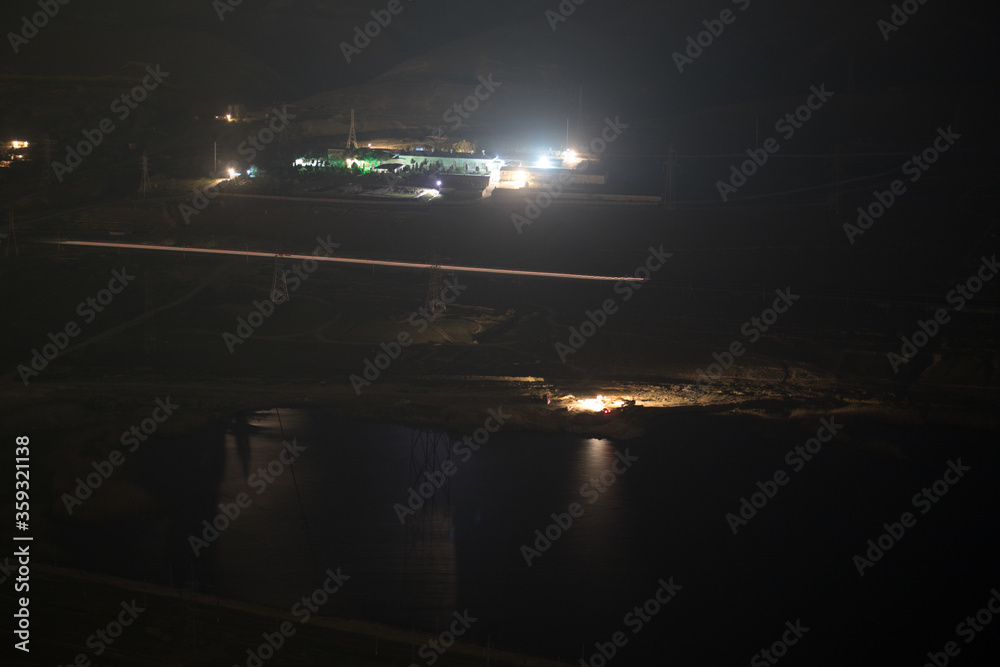 Night landscape of lake near road at mountains. Zoom shot with long exposure. Selective focus Night landscape of lake near road at mountains. Zoom shot with long exposure. Selective focus