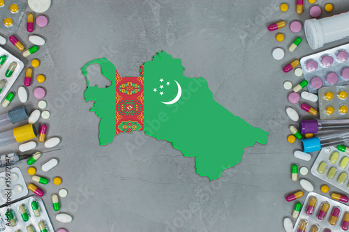 The Turkmenistan State began research for treatment and medicine to combat the pandemic outbreak disease coronavirus. Medicine, pills, needles, syringes and Turkmenistanmap and flag on gray background