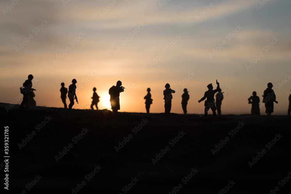 War Concept. Military silhouettes fighting scene on war fog sky background, World War Soldiers Silhouette Below Cloudy Skyline At sunset.