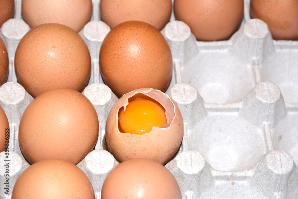 Broken egg among whole eggs in a package Broken egg among whole eggs in a package