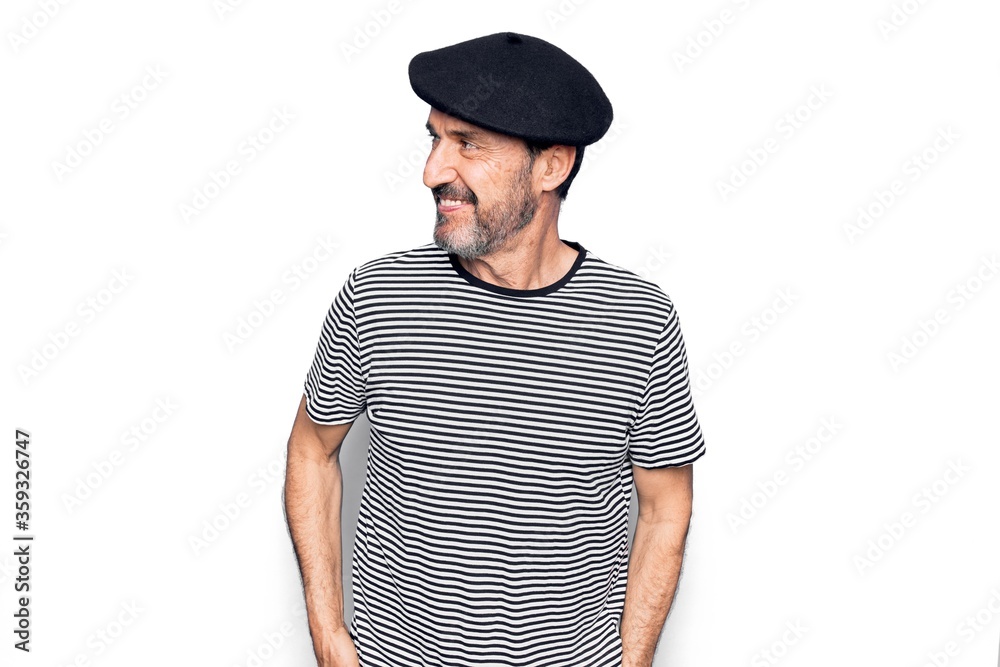 Middle age handsome man wearing striped t-shirt and french beret over white background looking to side, relax profile pose with natural face and confident smile. Middle age handsome man wearing striped t-shirt and french beret over white background looking to side, relax profile pose with natural face and confident smile.