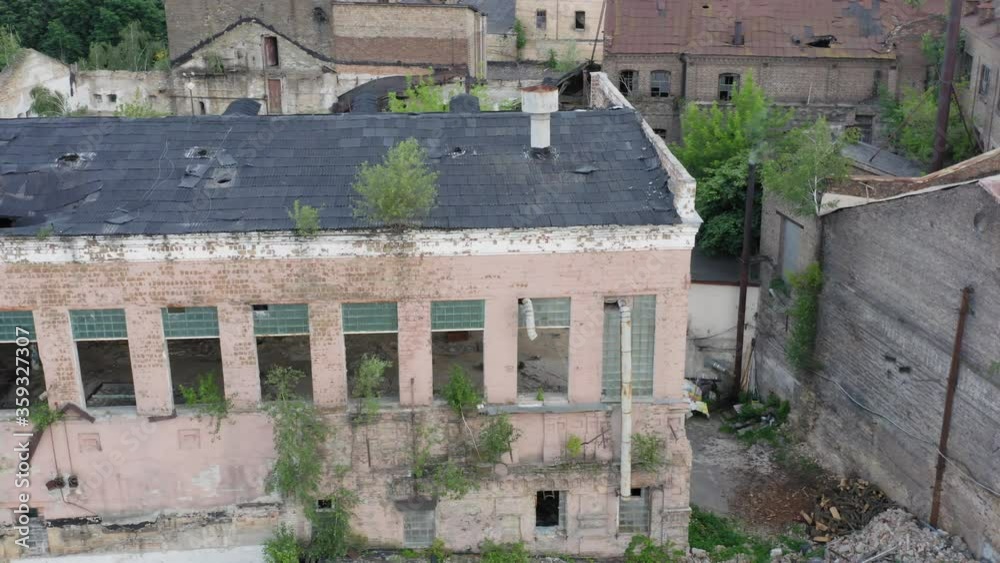 Abandoned production department or warehouse of an old factory. Industrial destroyed 19th century building with broken windows for demolition. Aerial view Abandoned production department or warehouse of an old factory. Industrial destroyed 19th century building with broken windows for demolition. Aerial view