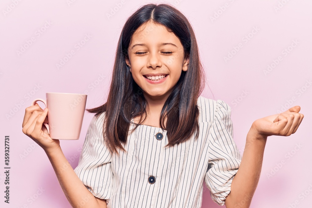 Beautiful child girl holding coffee screaming proud, celebrating victory and success very excited with raised arm Beautiful child girl holding coffee screaming proud, celebrating victory and success very excited with raised arm