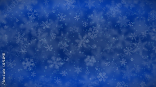 Christmas background of snowflakes of different shapes  sizes  blur and transparency in blue colors