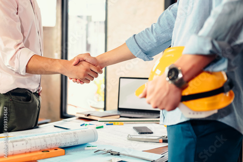 Architect and businessman handshake after finish an agreement in the office at site construction.