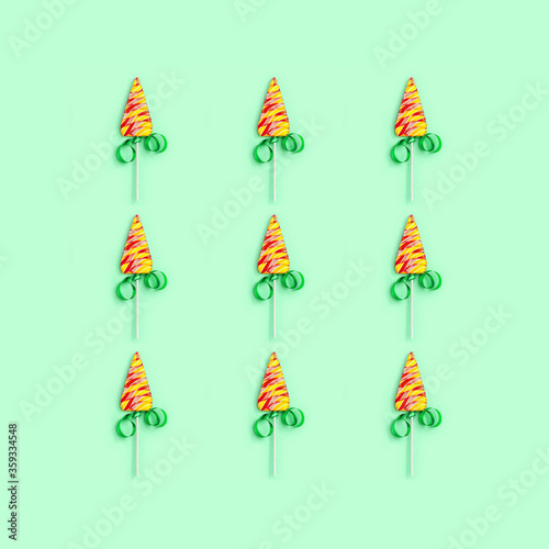 Christmas and New Year greetind card with lollipops shaped like Christmas tree on neo mint colored background.  Image for Print celebration packaging. photo