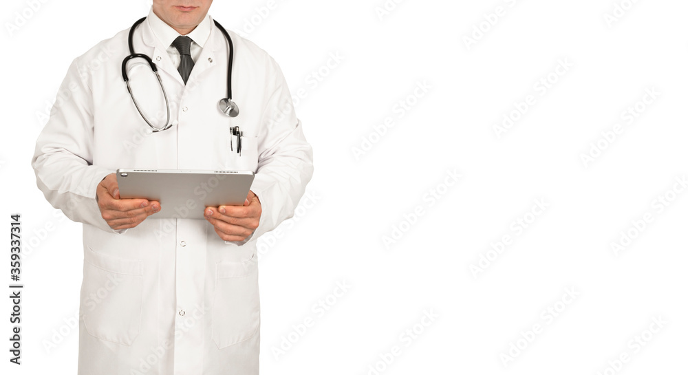 Male doctor standing in front of white background, wearing a mask and a white coat holding a tablet computer in his hand with a stethoscope around his neck.. Male doctor standing in front of white background, wearing a mask and a white coat holding a tablet computer in his hand with a stethoscope around his neck..