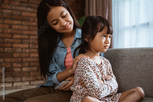 sister trying to apologize to sibling at home photo