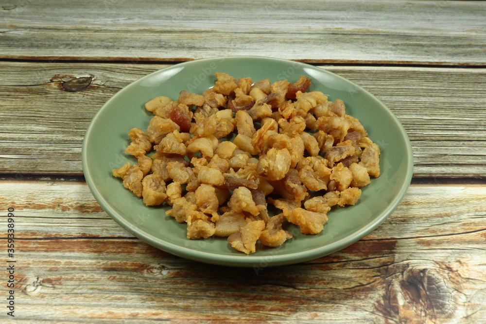 Pile of deep fried crispy belly pork on the plate. Famous appetizer snack and side dish in Thai restaurant. Popular oily food in Asia. Pile of deep fried crispy belly pork on the plate. Famous appetizer snack and side dish in Thai restaurant. Popular oily food in Asia.